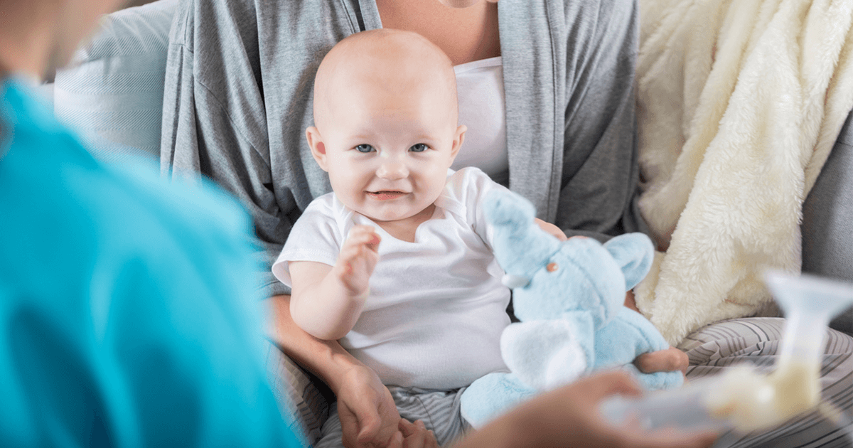 Woman holding infant with breast pump in foreground-Choosing the Right Breast Pump-Axia Women's Health