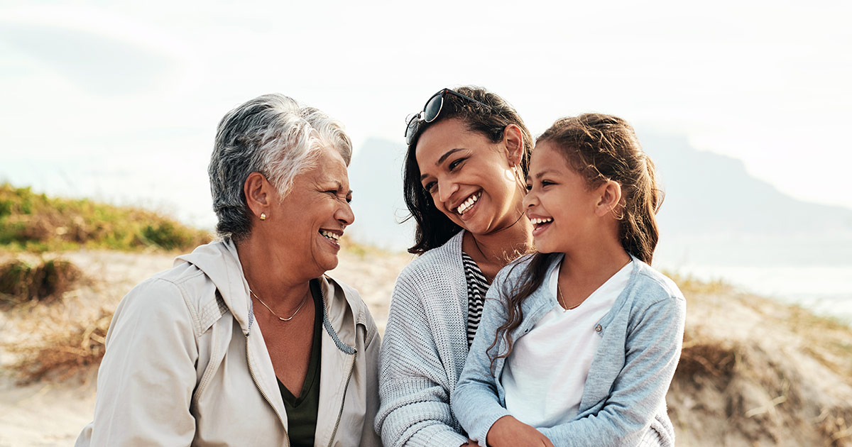 three generations of women standing outdoors looking at each other and smiling - Axia Women's Health
